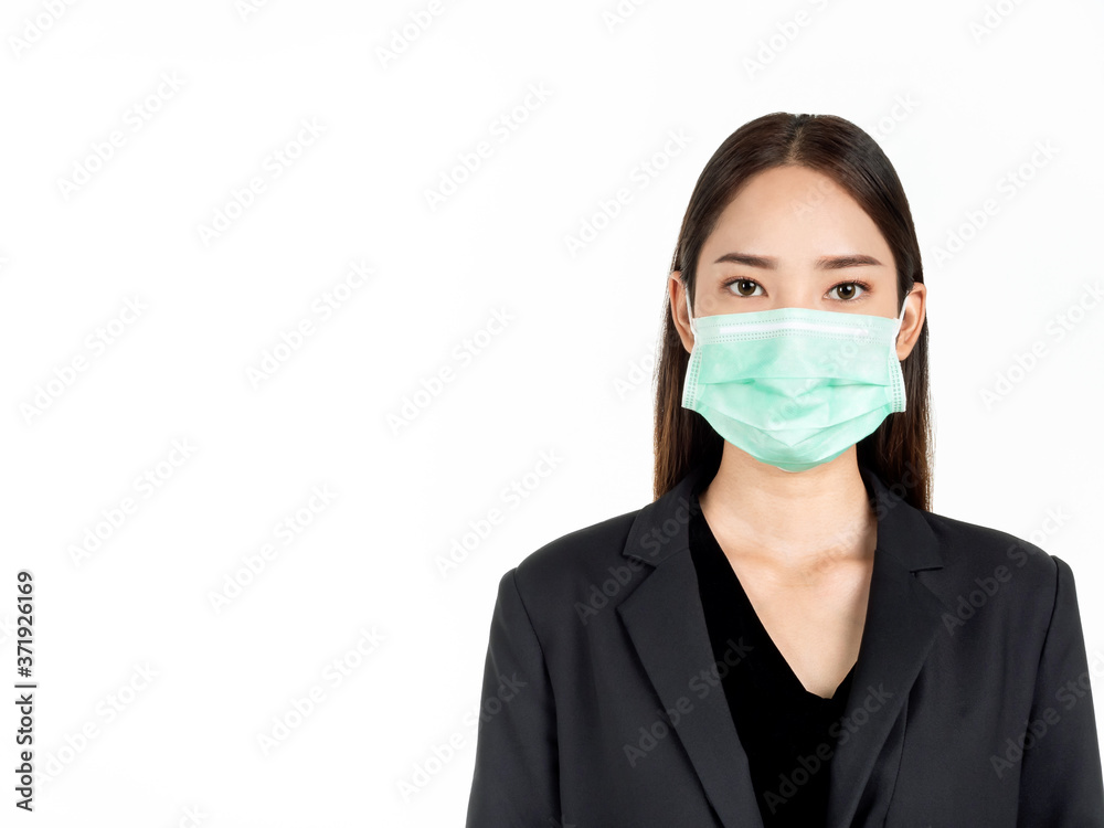 A confident beautiful young Asian business woman wearing green medical face mask and black suit. A confident beautiful young Asian business woman wearing green medical face mask and black suit.
