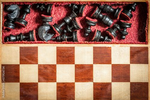 Chess pieces are stacked in trays outside the game.