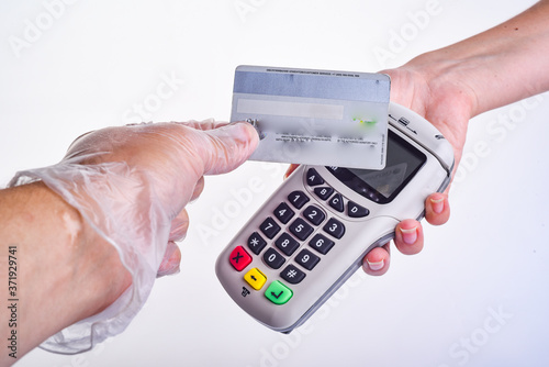 payment terminal. The buyer pays by card. Hands with gloves. Seller's hand in a glove. Buyer's hand in a glove. Safe shopping concept