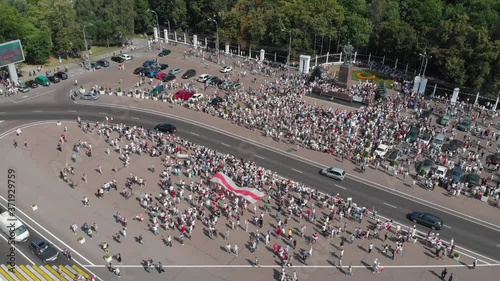 Gomel, Belarus - 08/16/2020: Peaceful activists protesting in the city. Presidential elections in Belarus 2020. Top veiw big flag used by Belarusian democratic opposition in 2020 photo