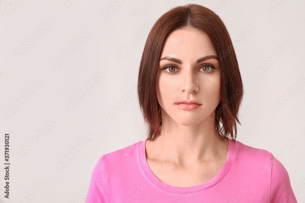 Young woman with cold sore on light background