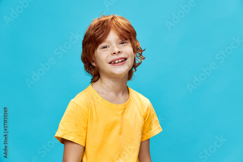 Boy mode with a beautiful smile and a yellow t-shirt blue background 