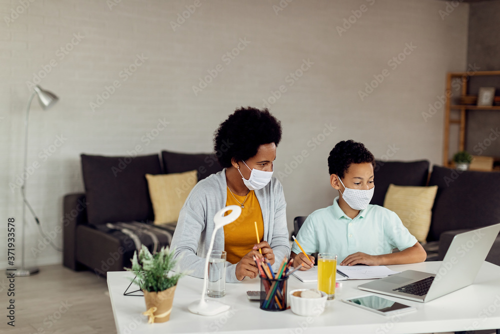 African American boy and his mother using laptop while homeschooling during virus pandemic. African American boy and his mother using laptop while homeschooling during virus pandemic.