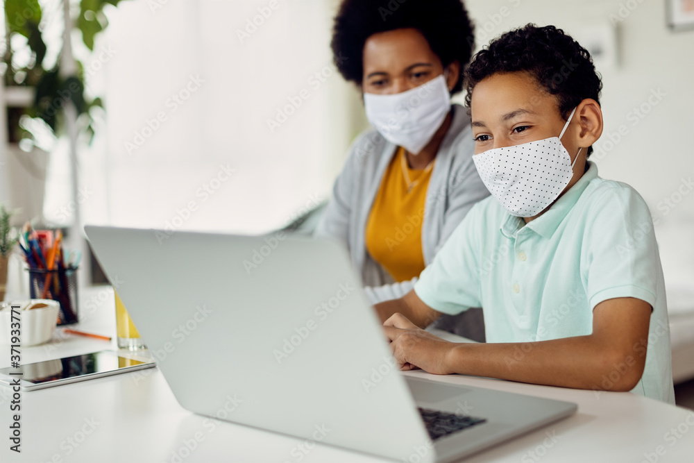 African American boy and his mother using computer while homeschooling during COVID-19 pandemic. African American boy and his mother using computer while homeschooling during COVID-19 pandemic.
