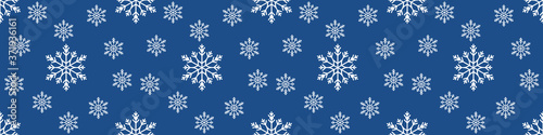 Christmas seamless pattern with snowflakes on pastel blue background. Winter background with snowfall. Endless Christmas Pattern. extra wide banner background