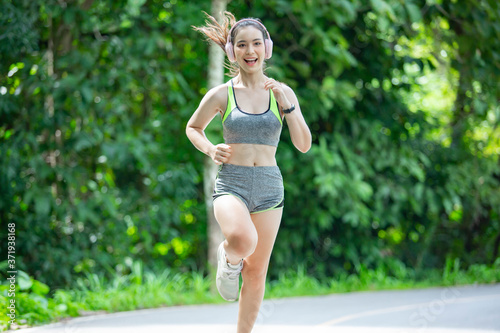 Beautiful Asian girls fitness runner running on a trail On roads and running in parks or nature trails