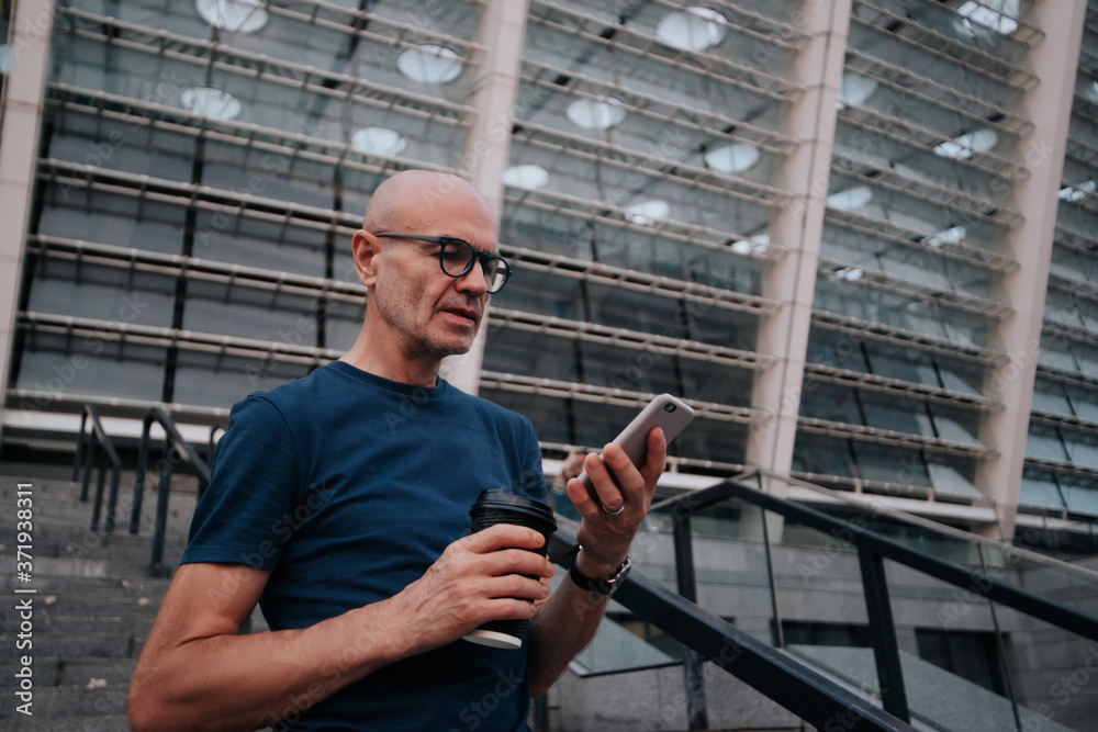 a man on the street drinks coffee and uses a mobile phone a man on the street drinks coffee and uses a mobile phone