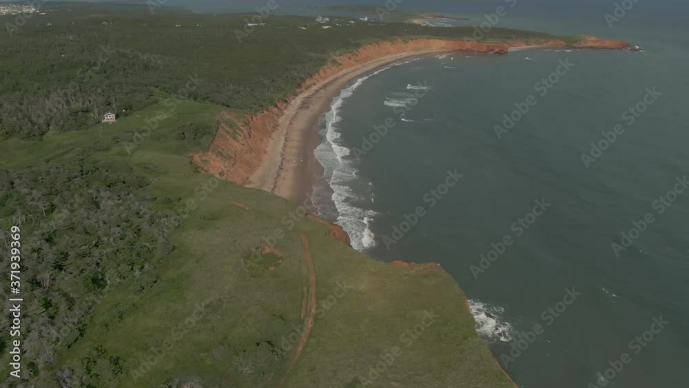 Aerial tilt reveal shot of waves breaking on empty Quebec island beach Aerial tilt reveal shot of waves breaking on empty Quebec island beach