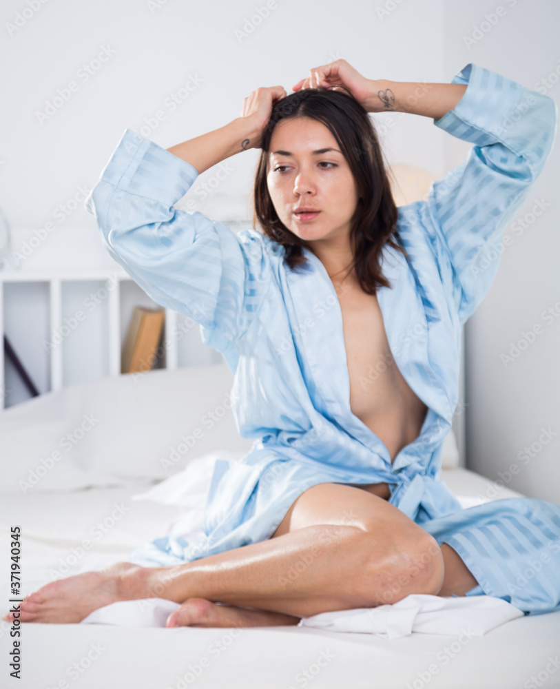 Seductive nude young sexy girl in bathrobe playfully posing in bed at home  Photos | Adobe Stock