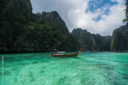 wood Boat in Crystal clear sea water at Ao Pi Leh is snorkeling point famous tour lagoon in Phi Phi Islands, Krabi