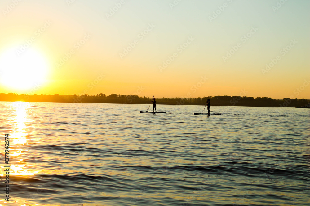 Stand-up surfing. Classes on the river at sunset.