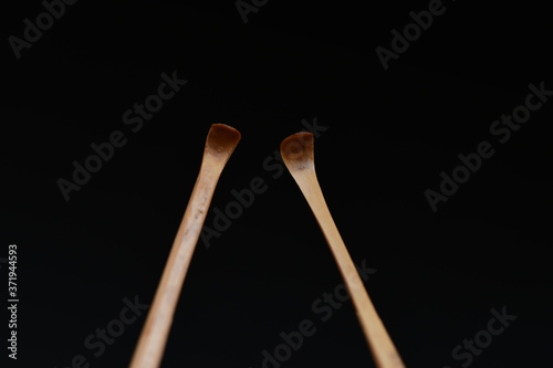 Handmade bamboo ear wax remover on black background. © makoto photo
