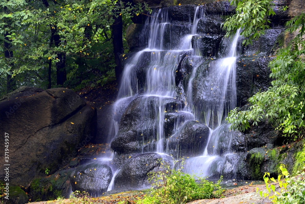 Picturesque beautiful waterfall falls from stones in Sofievsky park, Uman, Ukraine Picturesque beautiful waterfall falls from stones in Sofievsky park, Uman, Ukraine