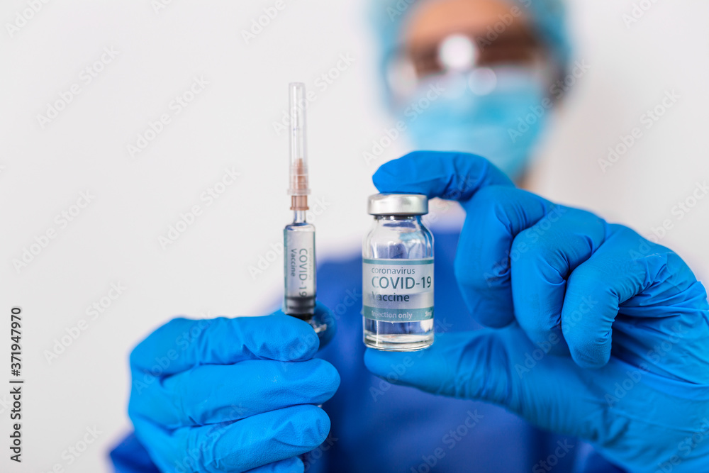 Doctor, nurse, scientist, researcher hand in blue gloves holding flu, measles, coronavirus, covid-19 vaccine disease preparing for human clinical trials vaccination shot, medicine and drug concept.