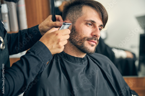 Kind young man enjoying the process of haircutting