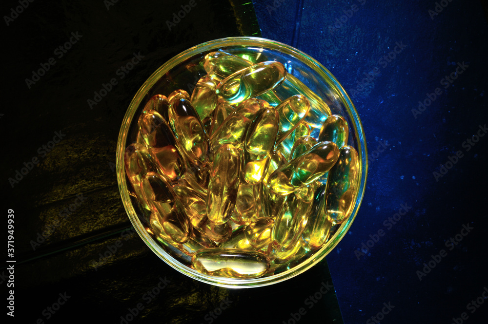 omega 3 capsule. In a glass bowl on a colored background. omega 3 capsule. In a glass bowl on a colored background.