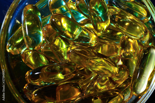 omega 3 capsule. In a glass bowl on a colored background.