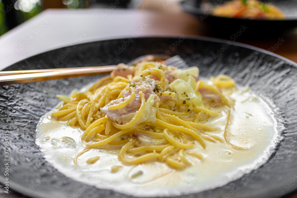 Creamy Spaghetti Carbonara in black dish served in the restaurant. Creamy Spaghetti Carbonara in black dish served in the restaurant.