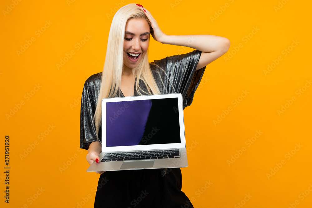 surprised girl holds laptop with template for web page on yellow background surprised girl holds laptop with template for web page on yellow background