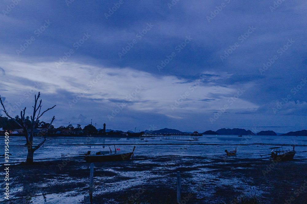 Landscape view of low tide sea and evening dark blue sky.