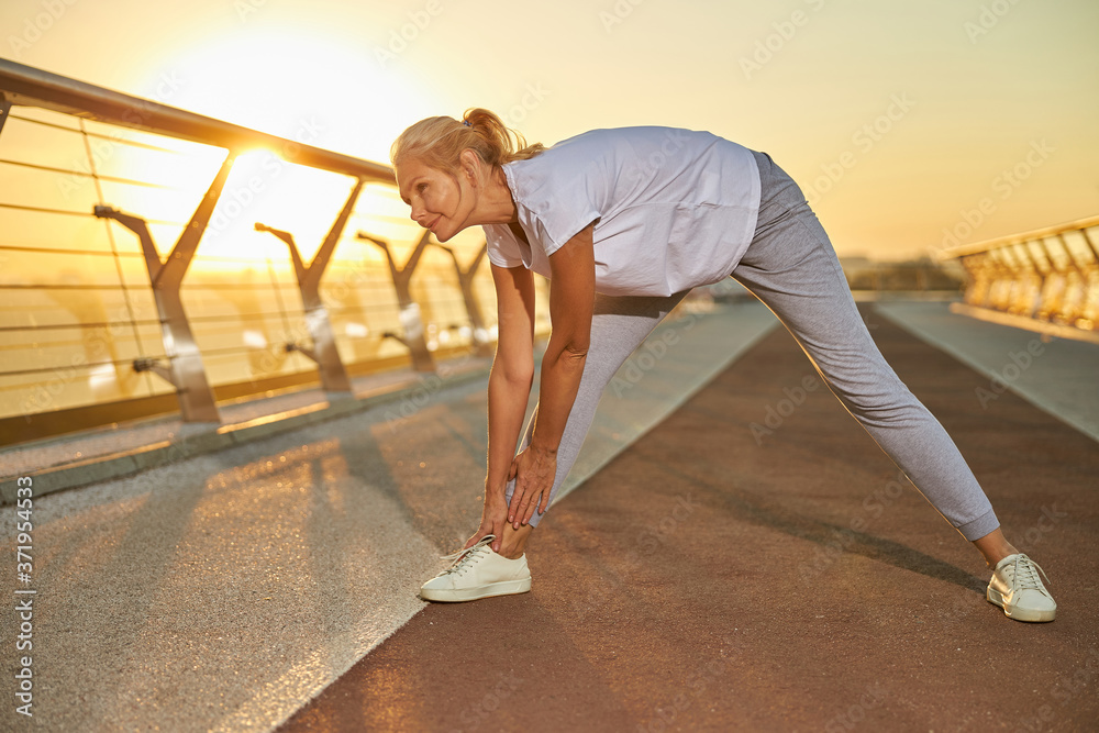 Naklejka premium Beautiful woman stretching legs on the bridge
