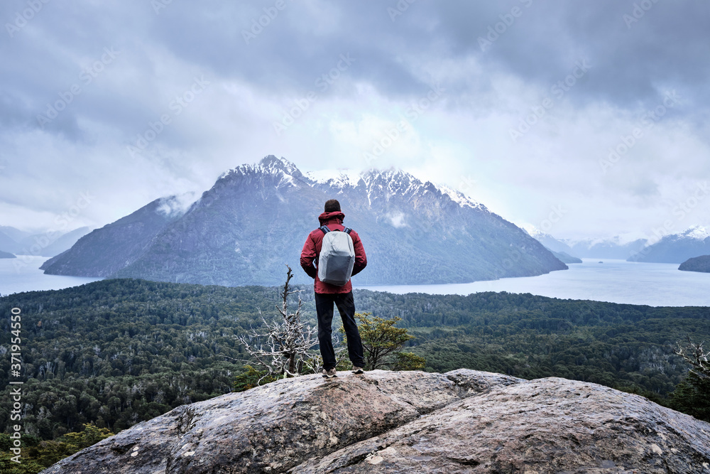 Fototapeta premium Unrecognized man in a mountain looking to the lake landscape