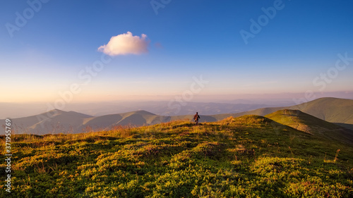 Lonely walker in a mountain path under a single cloud