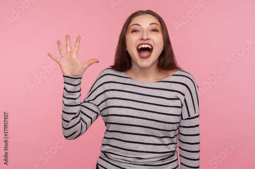 Hi, welcome! Portrait of happy amiable woman in striped sweatshirt waving hand with hello and smiling friendly to camera, expressing joy from meeting. indoor studio shot isolated on pink background
