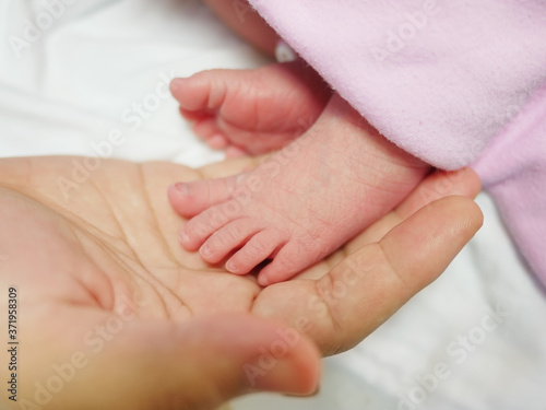 A lovely little foot of a newborn baby placed on her mother's hand Looks so nurturing, baby newborn concept