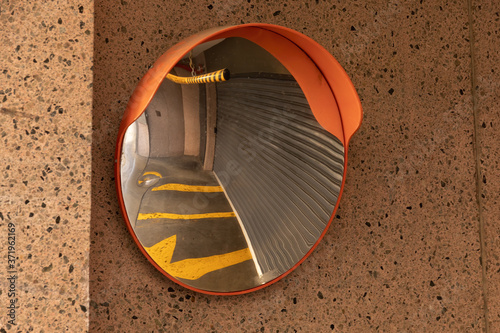 Old dirty convex mirror in building driveway photo
