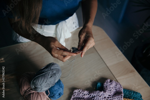 Sewing concept. Woman knitting at the table in a tailor shop. Tailor working concept. Hobby concept.