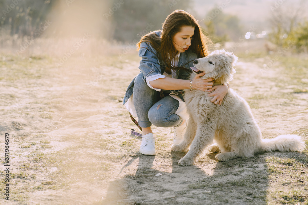 Woman in a spring forest. Girl with cute dog. Brunette in a jeans jacket. Woman in a spring forest. Girl with cute dog. Brunette in a jeans jacket.