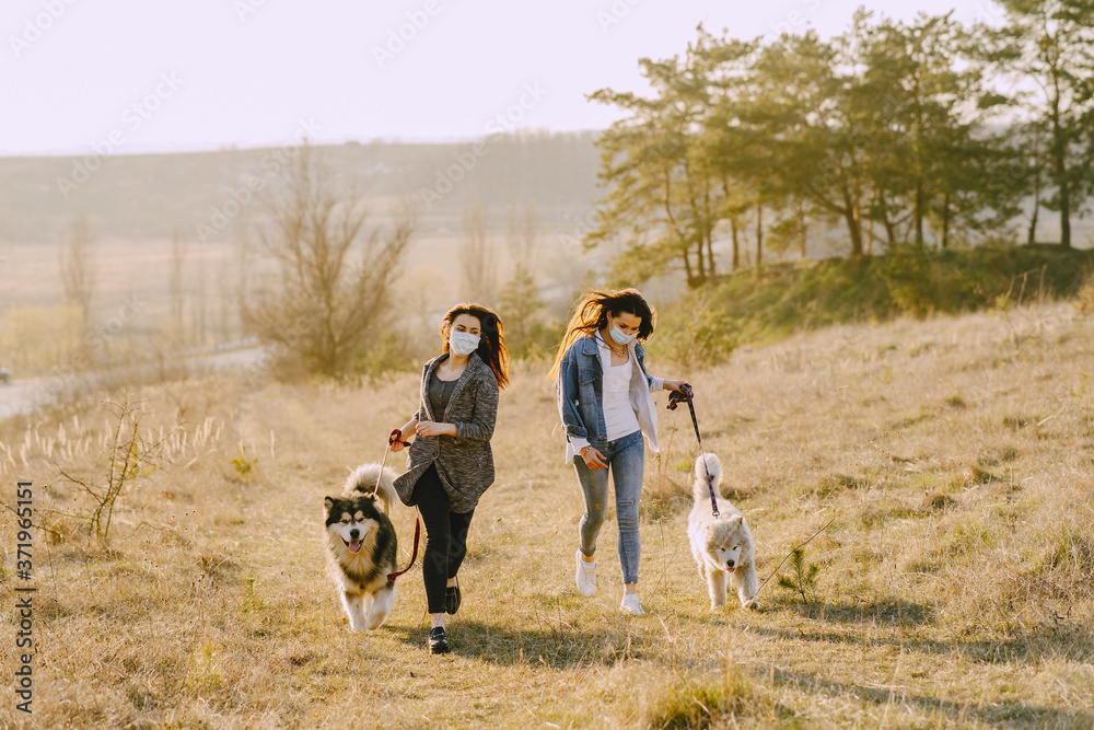 Women in a masks in a spring forest. Girls with cute dogs. Corona virus. Women in a masks in a spring forest. Girls with cute dogs. Corona virus.