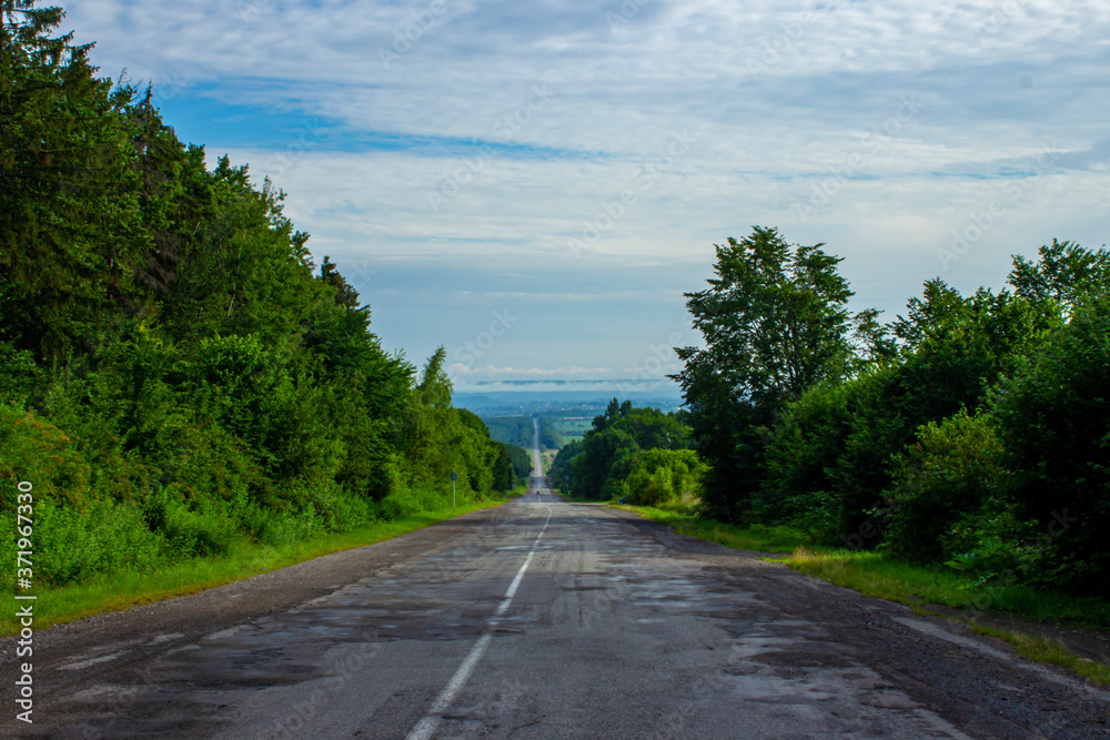 
asphalt road with a mountain landscape in the background