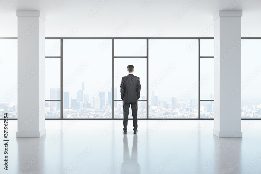 Businessman standing in modern gallery interior Businessman standing in modern gallery interior