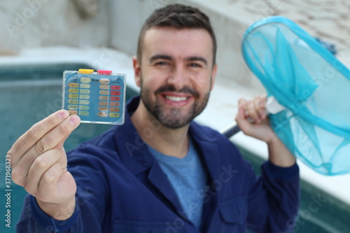 Janitor using Water Quality PH/CL2 Chlorine Tester Level Meter in Swimming Pool  photo