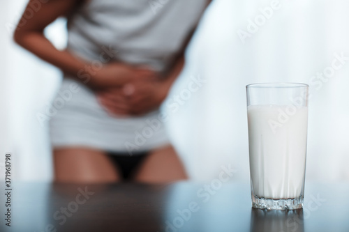 lactose intolerance concept. A woman feels bad, has an upset stomach, bloating due to lactose intolerance. photo