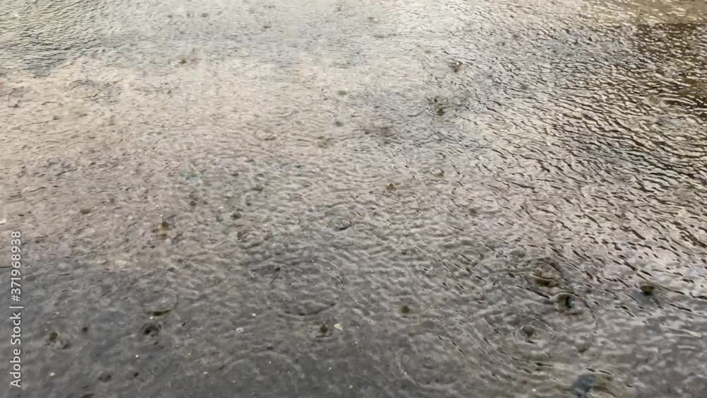 4K-Slow Motion, rain water drops falling into big puddle on old concrete, flooding the street. Road floods due to the heavy rain in wet season. Raindrops falling down. 4K-Slow Motion, rain water drops falling into big puddle on old concrete, flooding the street. Road floods due to the heavy rain in wet season. Raindrops falling down.