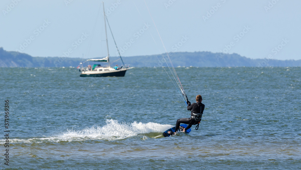 Naklejka premium KITESURFER - Active recreation on the water during a seaside holiday 