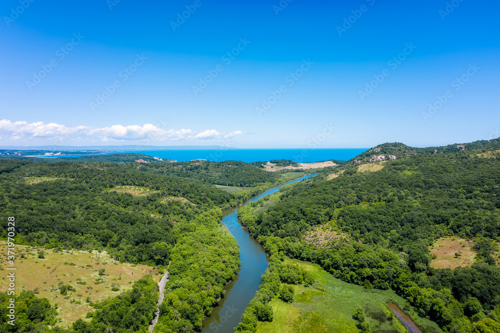 Aerial view of the picturesque curves of a river among lush vegetation that flows into the sea, Ropotamo River in Ropotamo Nature Reserve, Strandzha Mountain