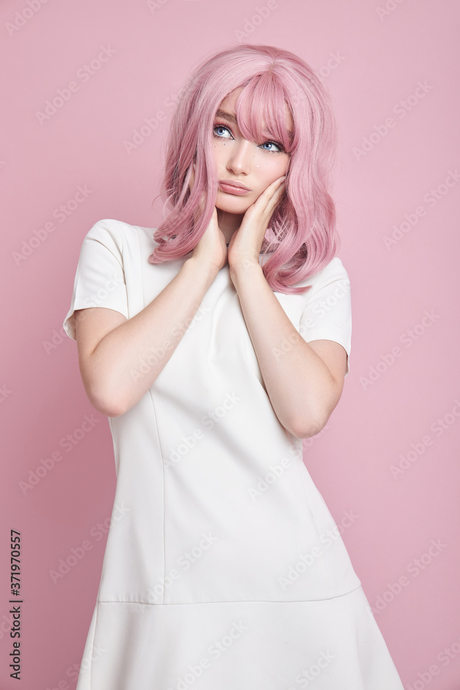 Cute girl with long pink hair, hair coloring. Beautiful woman on a pink background in a white dress. Colored hair, perfect hairstyle, beauty and care Cute girl with long pink hair, hair coloring. Beautiful woman on a pink background in a white dress. Colored hair, perfect hairstyle, beauty and care