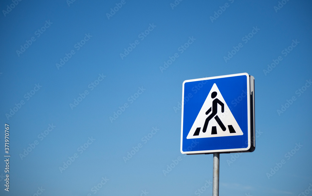 Road sign Pedestrian crossing on a background of blue sky Road sign Pedestrian crossing on a background of blue sky