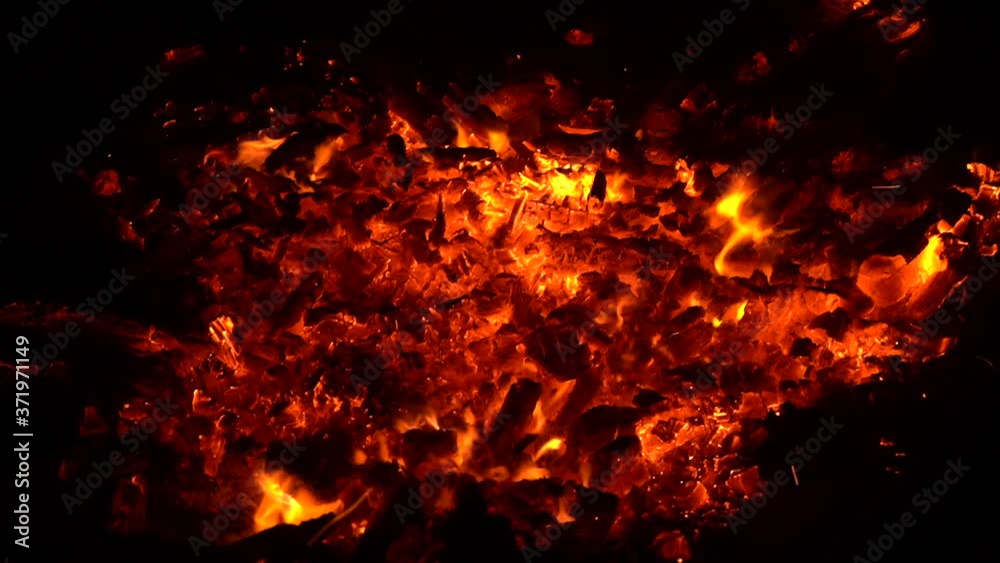 close up of burning coals in a bonfire at night background close up of burning coals in a bonfire at night background