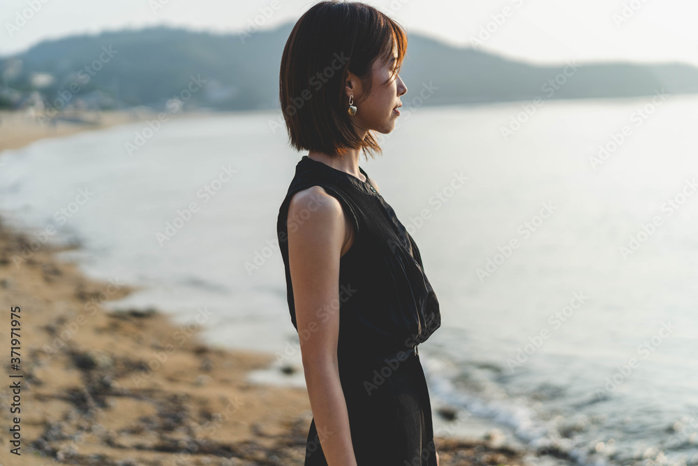 夕陽の海にいる女性