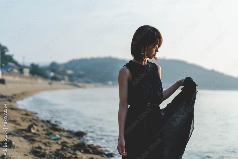 夕陽の海にいる女性