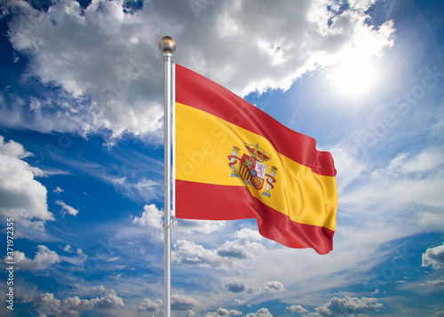 Realistic flag. 3D illustration. Colored waving flag of Spain on sunny blue sky background.