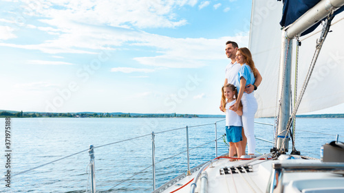 Family Standing On Yacht Deck Sailing Across The Sea, Panorama © Prostock-studio