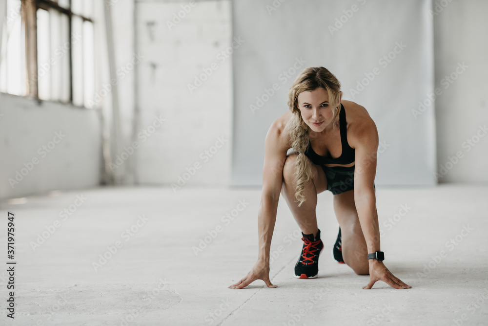 Workout, run and start. Muscular fit woman in sportswear with fitness tracker exercising in gym Workout, run and start. Muscular fit woman in sportswear with fitness tracker exercising in gym