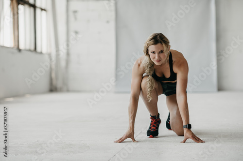 Workout, run and start. Muscular fit woman in sportswear with fitness tracker exercising in gym