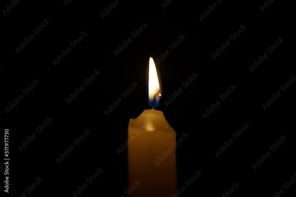 Burning candle on a black background in the dark at night. Burning candle on a black background in the dark at night.